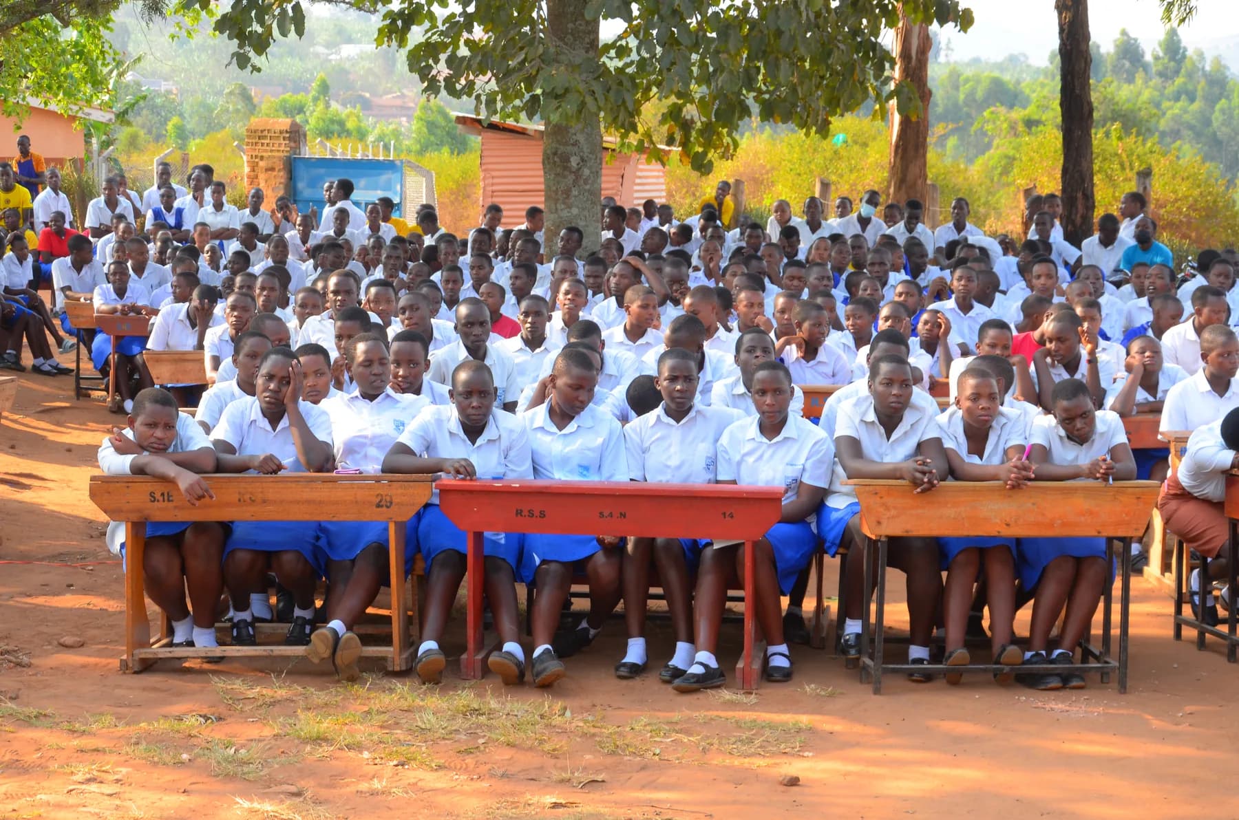 Rubaare Secondary School students seated outdoors during a school gathering.